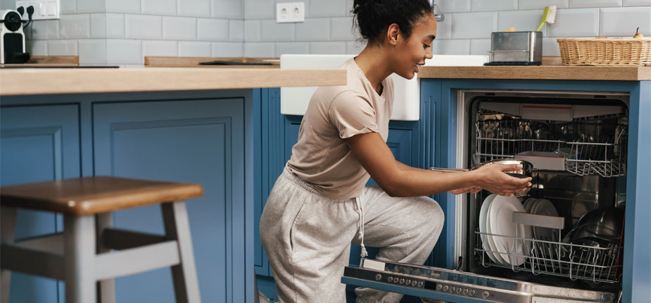 Woman using her energy efficient dishwasher